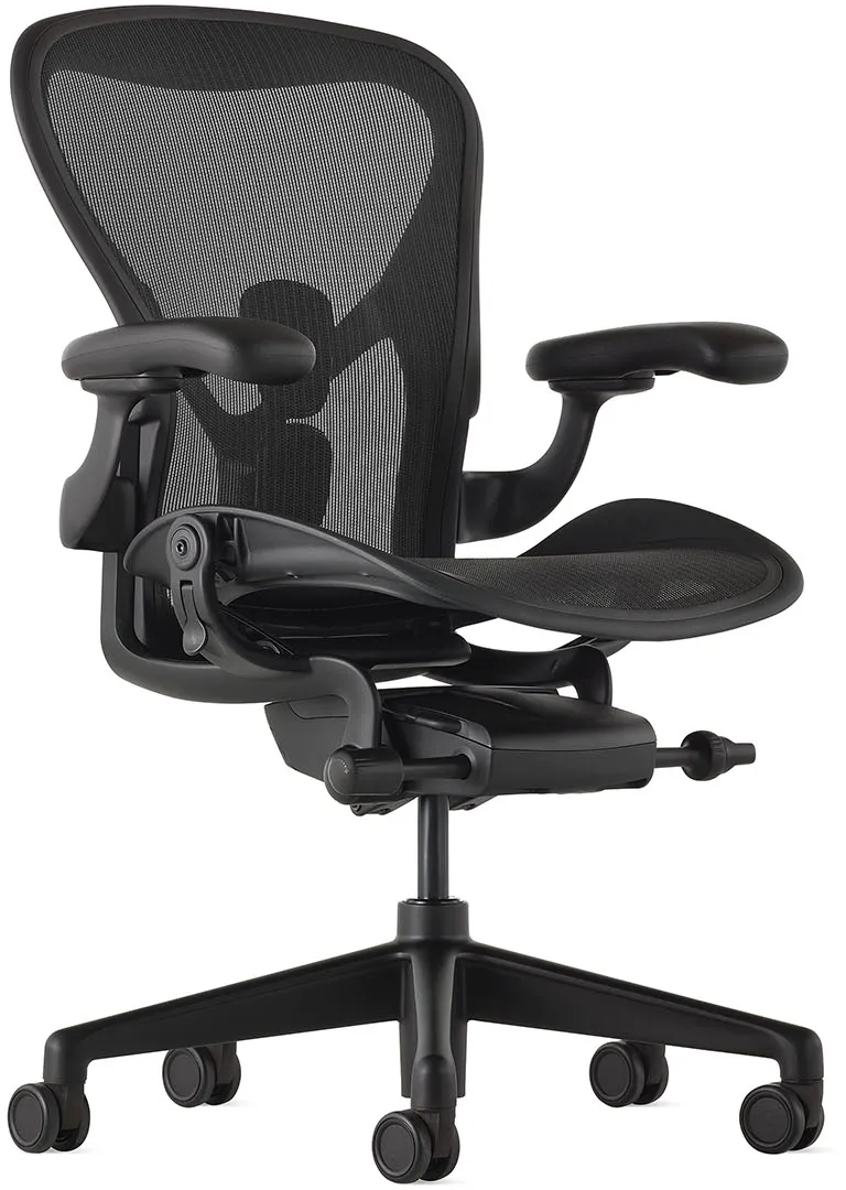 A modern ergonomic office chair, specifically the iconic Herman Miller Aeron chair, shown against a plain white background. It features a black mesh backrest and seat for breathable support, with fully adjustable padded armrests. The chair’s curved backrest is designed for lumbar support, and the seat is contoured for comfort. Its five-wheel base and adjustable tilt and height controls make it a high-end option for office or home workspace ergonomics.