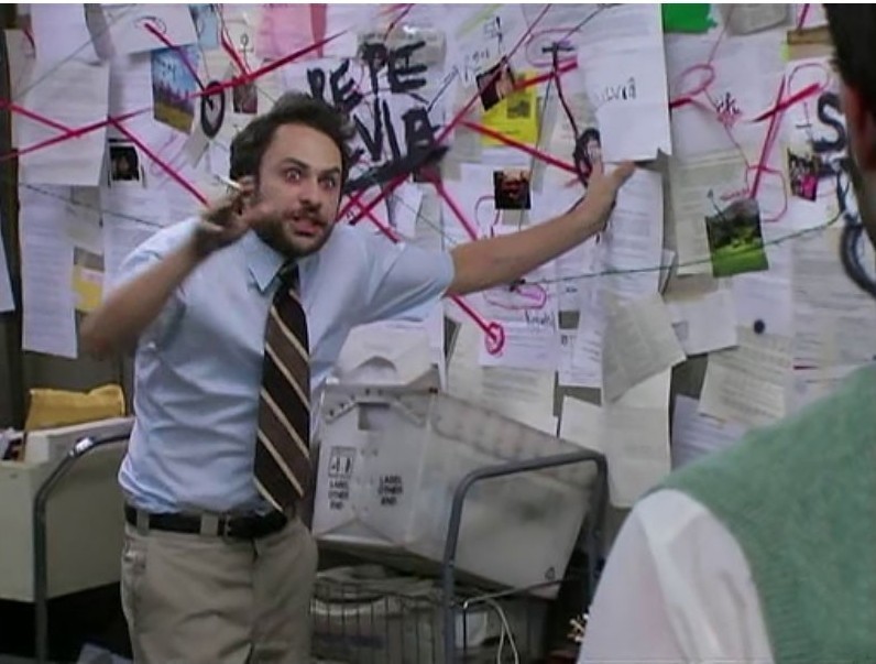 A frazzled man in a shirt and tie gestures wildly in front of a chaotic wall covered with papers and photos connected by red string, the classic “evidence board” trope, suggesting an obsessive attempt to connect far-fetched dots.