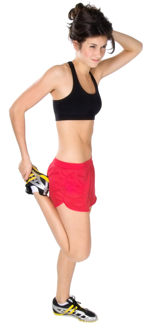 Photo of a woman in running clothes doing a conventional quads stretch, pulling her heel up behind her butt.