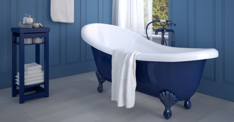 Photo of a classy antique porcelain clawfoot tub with deep navy blue lacquer in a bathroom with matching blue walls and furniture.