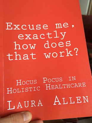 Photo of a hand holding a copy of the book "Excuse me, exactly how does that work?" by Laura Allen