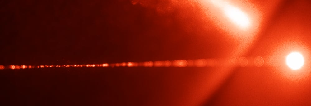 A laser shining through a cloud of particles.