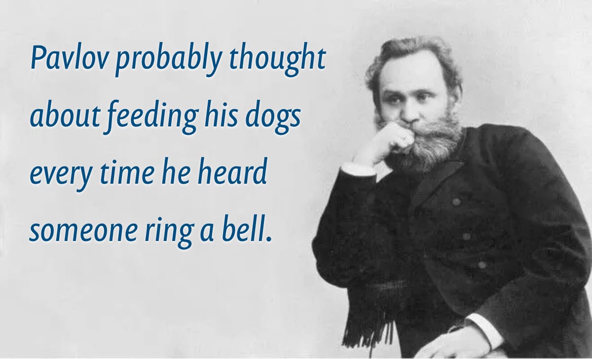 A B&W photograph of Ivan Pavlov, the famous Russian neurologist and physiologist, seated with his hand resting on his chin in a contemplative pose. To the left of the image is a humorous caption reading: “Pavlov probably thought about feeding his dogs every time he heard someone ring a bell.”