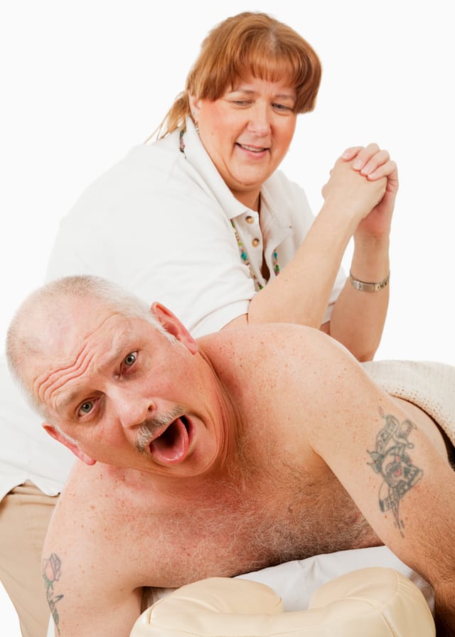 Photograph of a man receiving a painful deep tissue massage from a sterotyped stocky female massage therapist.