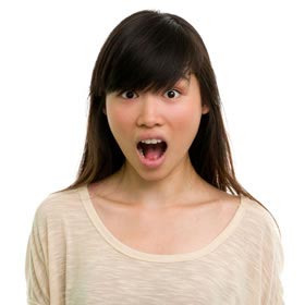 Photograph of a young woman holding her mouth wide open, stretching her masticatory muscles and temporomandibular joint.